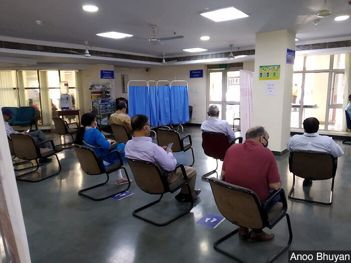 People wait after taking their COVID-19 vaccination at Delhi's Ram Manohar Lohia Hospital. Recipients are asked to wait 30 minutes after their shot to monitor for adverse reactions.